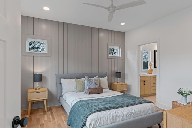 bedroom featuring connected bathroom, light hardwood / wood-style flooring, and ceiling fan