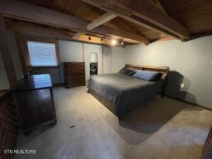 bedroom with wood ceiling, carpet floors, and beamed ceiling