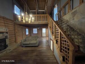 wine cellar featuring a towering ceiling, log walls, dark hardwood / wood-style flooring, and a notable chandelier