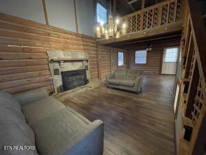 living room featuring a towering ceiling, dark hardwood / wood-style floors, and log walls