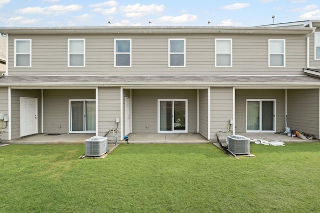 back of property with central AC, a lawn, and a patio area