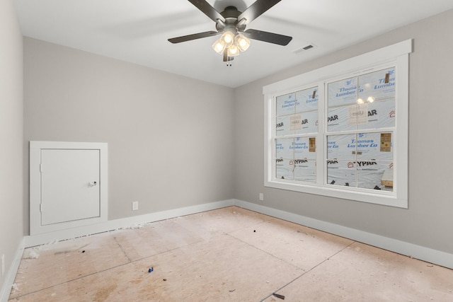 spare room with baseboards, visible vents, and a ceiling fan