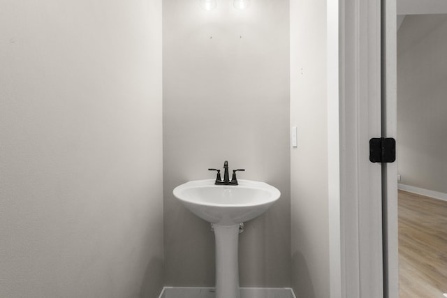 bathroom with wood finished floors and baseboards