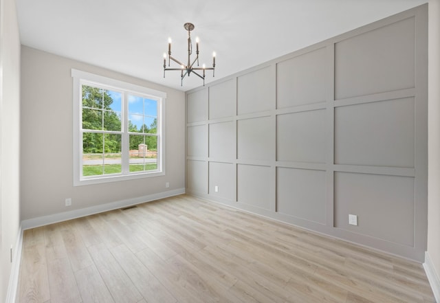 220 Birnam Wood Trce, Clarksville, TN 37043 - unfurnished dining area with a chandelier, baseboards, light wood-style flooring, and a decorative wall