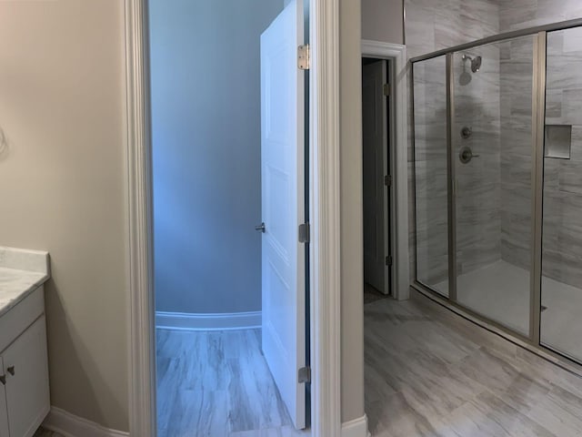 bathroom featuring walk in shower and vanity