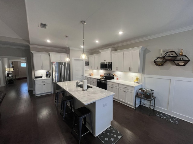 kitchen featuring white cabinetry, appliances with stainless steel finishes, sink, and a center island with sink