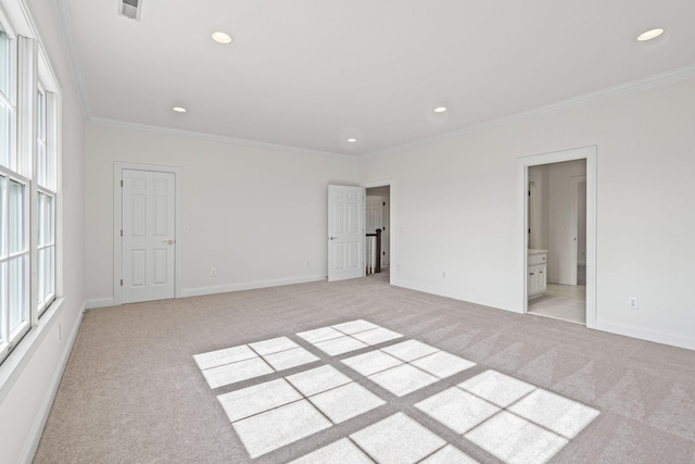 empty room with ornamental molding and light colored carpet