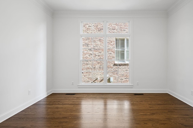 spare room featuring dark wood-type flooring and ornamental molding