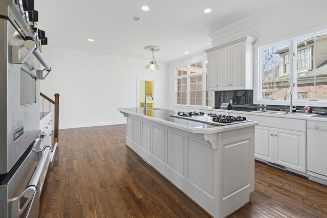 kitchen with white cabinetry, ornamental molding, white gas stovetop, and a kitchen island