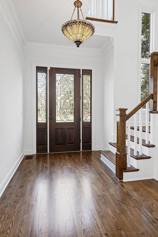 entrance foyer featuring dark hardwood / wood-style flooring, plenty of natural light, and ornamental molding