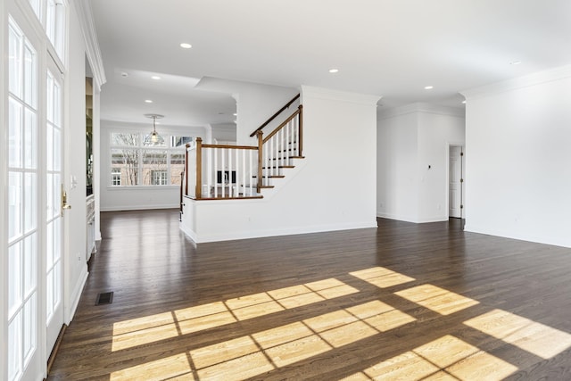 unfurnished living room featuring ornamental molding and dark hardwood / wood-style flooring