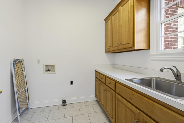 washroom featuring sink, hookup for a washing machine, cabinets, light tile patterned flooring, and hookup for an electric dryer