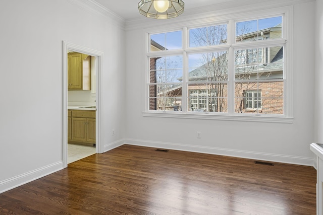 empty room featuring ornamental molding and dark hardwood / wood-style flooring