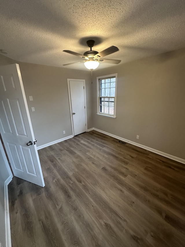 unfurnished bedroom featuring dark wood-type flooring, ceiling fan, and a textured ceiling