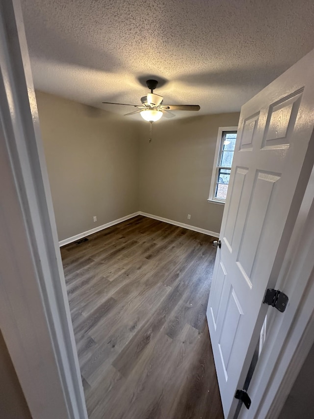 unfurnished bedroom featuring ceiling fan, dark hardwood / wood-style floors, and a textured ceiling