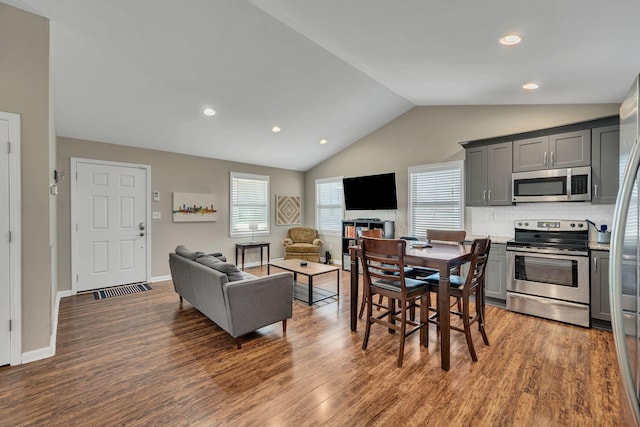 dining space with dark wood-type flooring and lofted ceiling