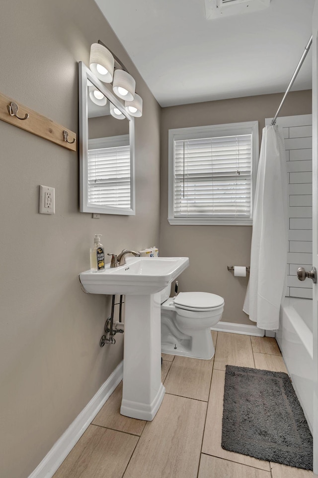 bathroom with toilet and shower / bath combo with shower curtain