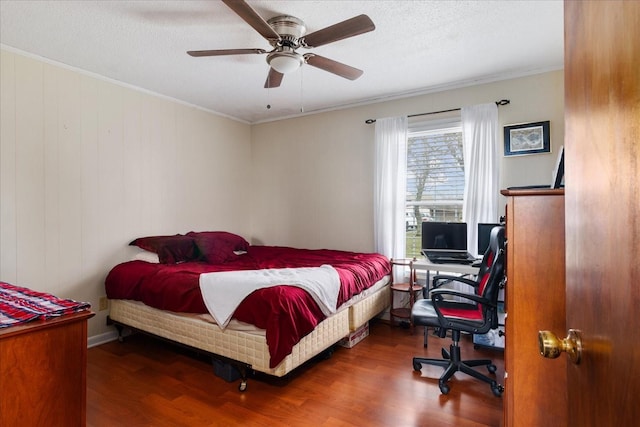 bedroom with crown molding, ceiling fan, and hardwood / wood-style floors