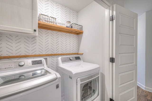 clothes washing area featuring independent washer and dryer, wood finished floors, cabinet space, and baseboards