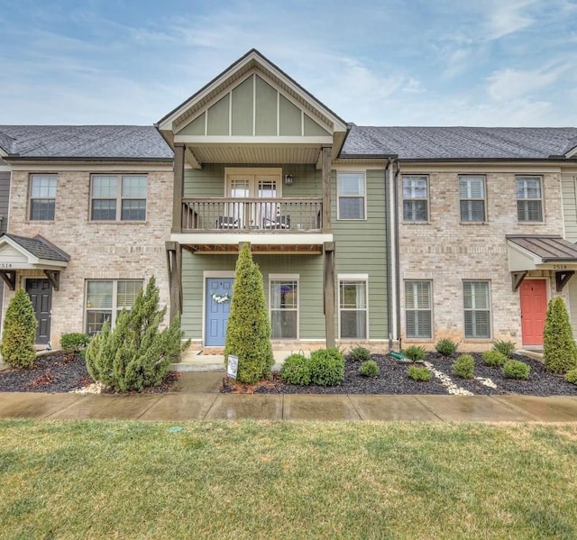 view of property featuring a front yard and a balcony