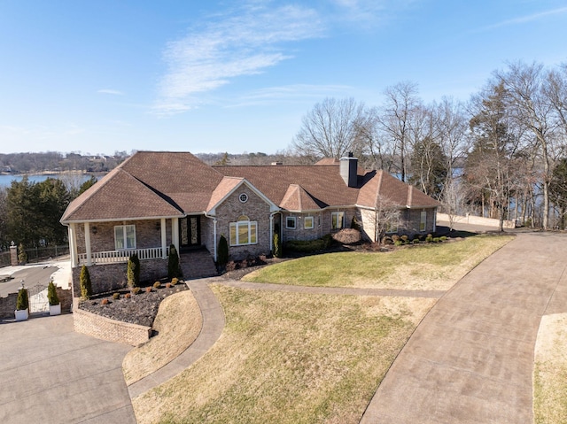 ranch-style home featuring a front lawn and covered porch