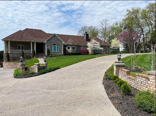 view of front of property featuring covered porch and a front lawn