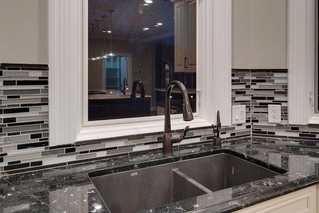 interior details with tasteful backsplash, sink, and dark stone counters