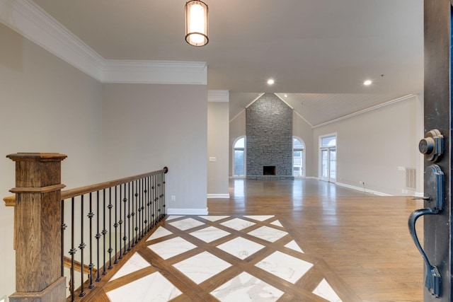 living room featuring crown molding, a stone fireplace, high vaulted ceiling, and light wood-type flooring