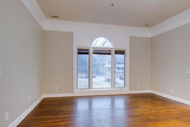 spare room with ornamental molding and dark hardwood / wood-style flooring