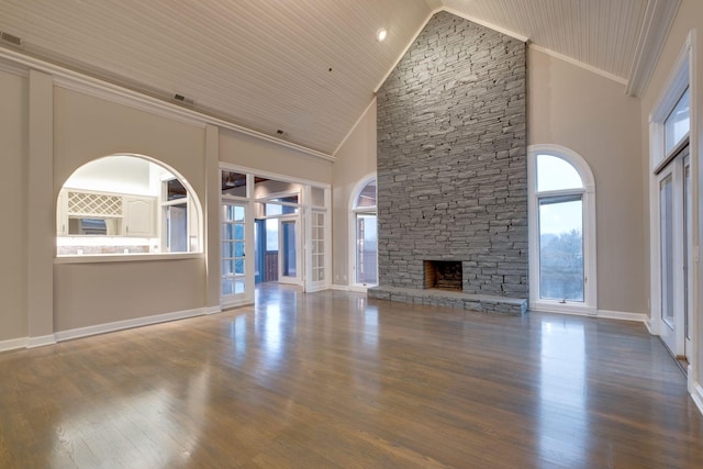 unfurnished living room featuring crown molding, high vaulted ceiling, a stone fireplace, and hardwood / wood-style floors