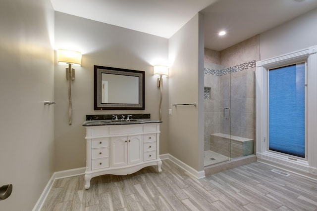 bathroom featuring vanity, an enclosed shower, and wood-type flooring