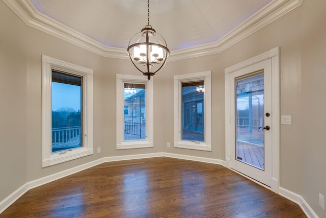 unfurnished dining area with crown molding, dark wood-type flooring, and a chandelier