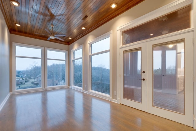 unfurnished sunroom with ceiling fan, wood ceiling, and french doors