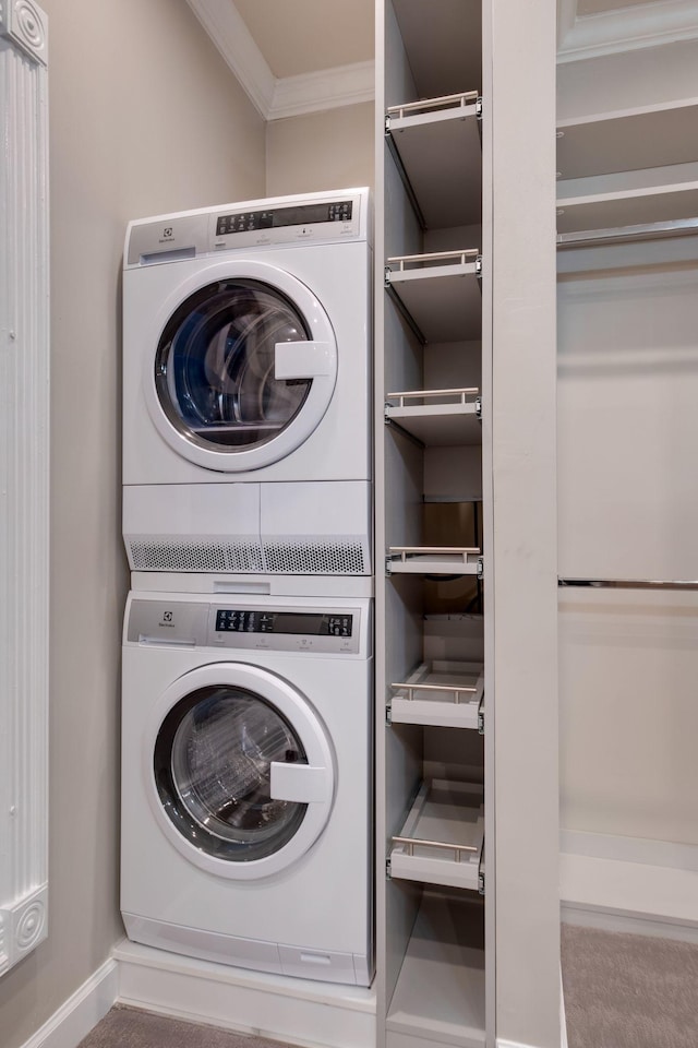 clothes washing area with ornamental molding and stacked washing maching and dryer