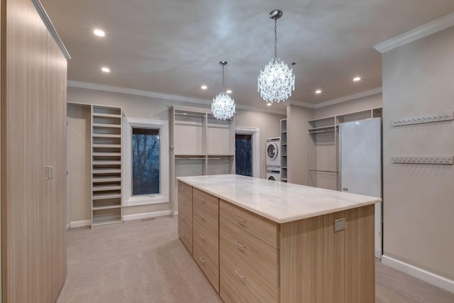 kitchen with a large island, hanging light fixtures, stacked washer and clothes dryer, light stone countertops, and light carpet