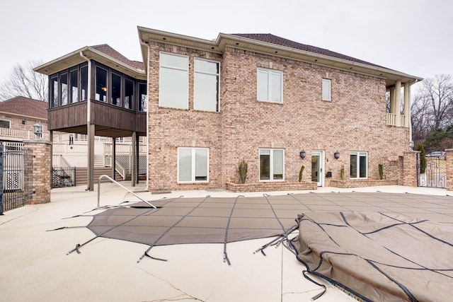 rear view of house featuring a sunroom and a patio