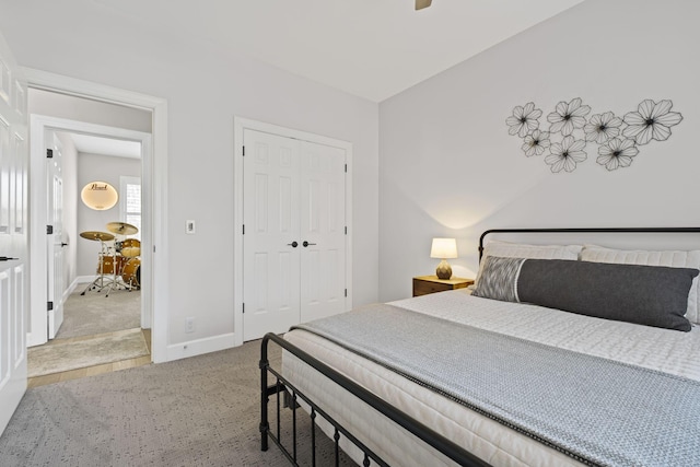 carpeted bedroom with ceiling fan and a closet