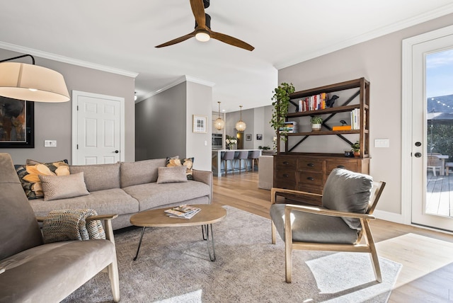 living room with crown molding, ceiling fan, and light hardwood / wood-style flooring