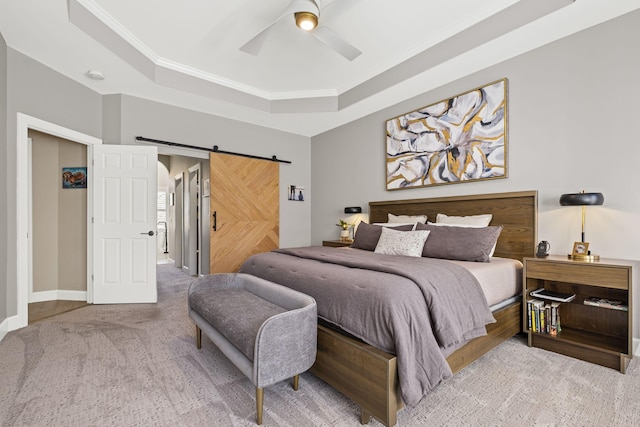 bedroom with carpet, ceiling fan, a raised ceiling, crown molding, and a barn door