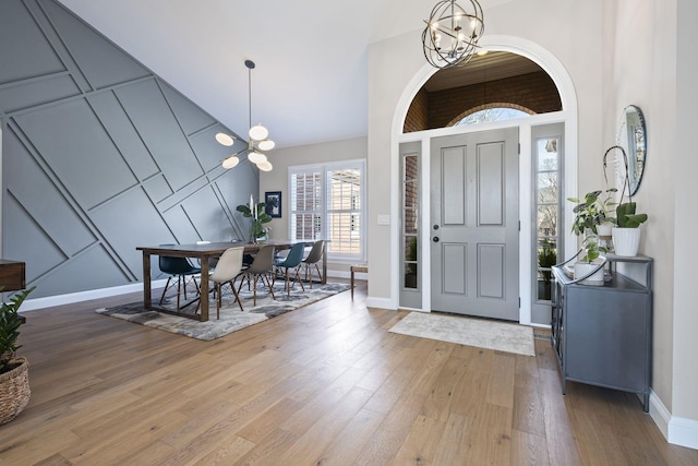 foyer entrance with a chandelier, hardwood / wood-style floors, and a high ceiling