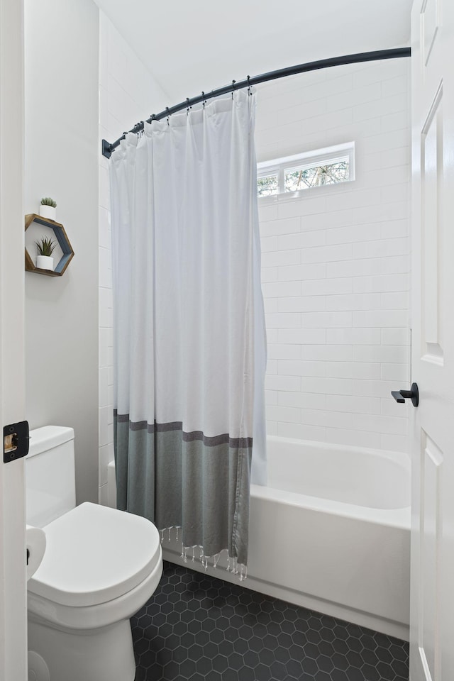 bathroom with shower / bath combo, tile patterned floors, and toilet