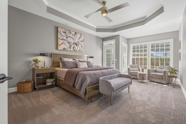 bedroom featuring crown molding, a tray ceiling, carpet floors, and ceiling fan