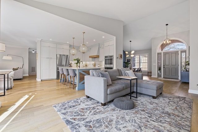 living room with light hardwood / wood-style floors and a notable chandelier