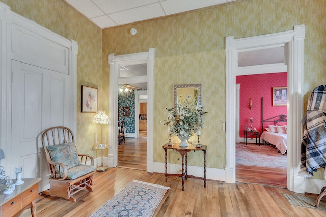 sitting room with a paneled ceiling and light hardwood / wood-style floors