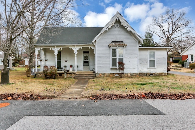 victorian house with a front lawn and a porch