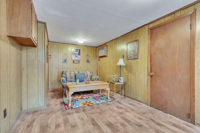 interior space with wood walls, light hardwood / wood-style flooring, and an AC wall unit