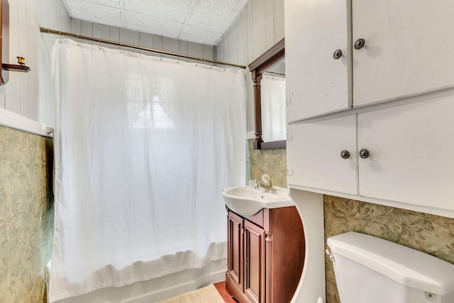 full bathroom featuring shower / tub combo with curtain, vanity, toilet, and a paneled ceiling