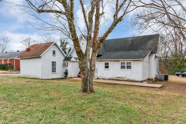 rear view of property featuring a yard and central air condition unit