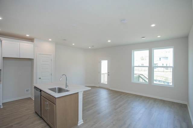 kitchen featuring dishwasher, sink, a center island with sink, and light hardwood / wood-style flooring