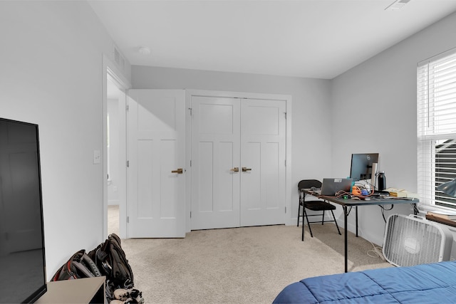 bedroom featuring light carpet and a closet